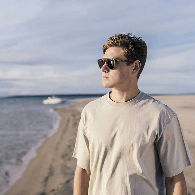 man wearing sunglasses on a sandy beach