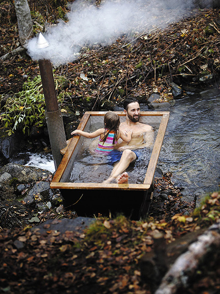 Man and child in outdoor bathtub