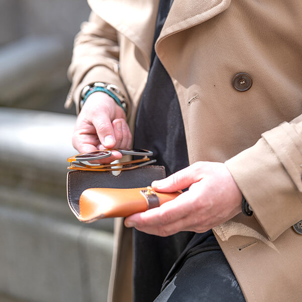 Man putting sunglasses into leather case