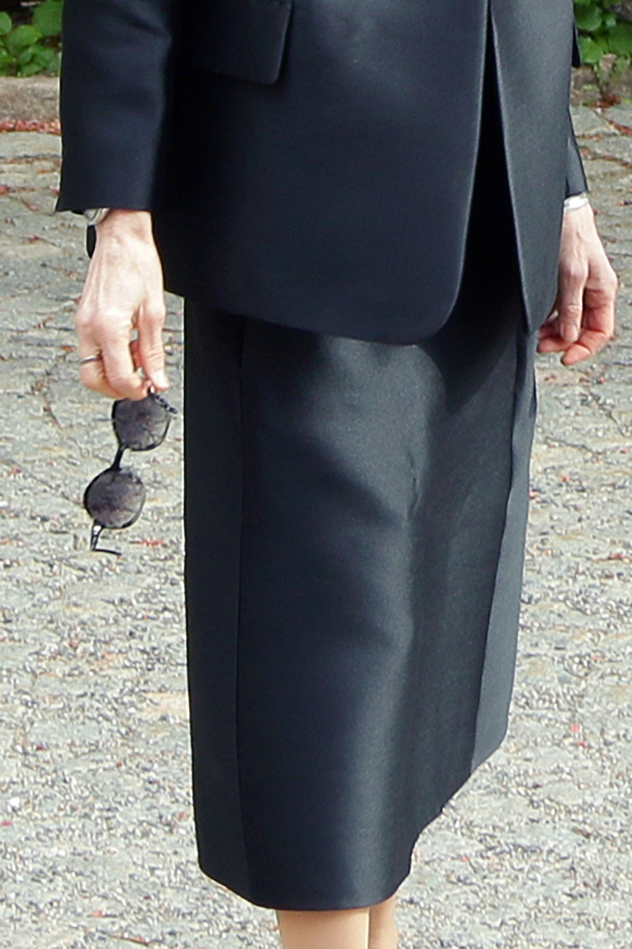woman holding sunglasses wearing all black