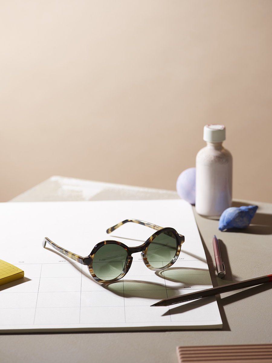 round sunglasses on a table with props